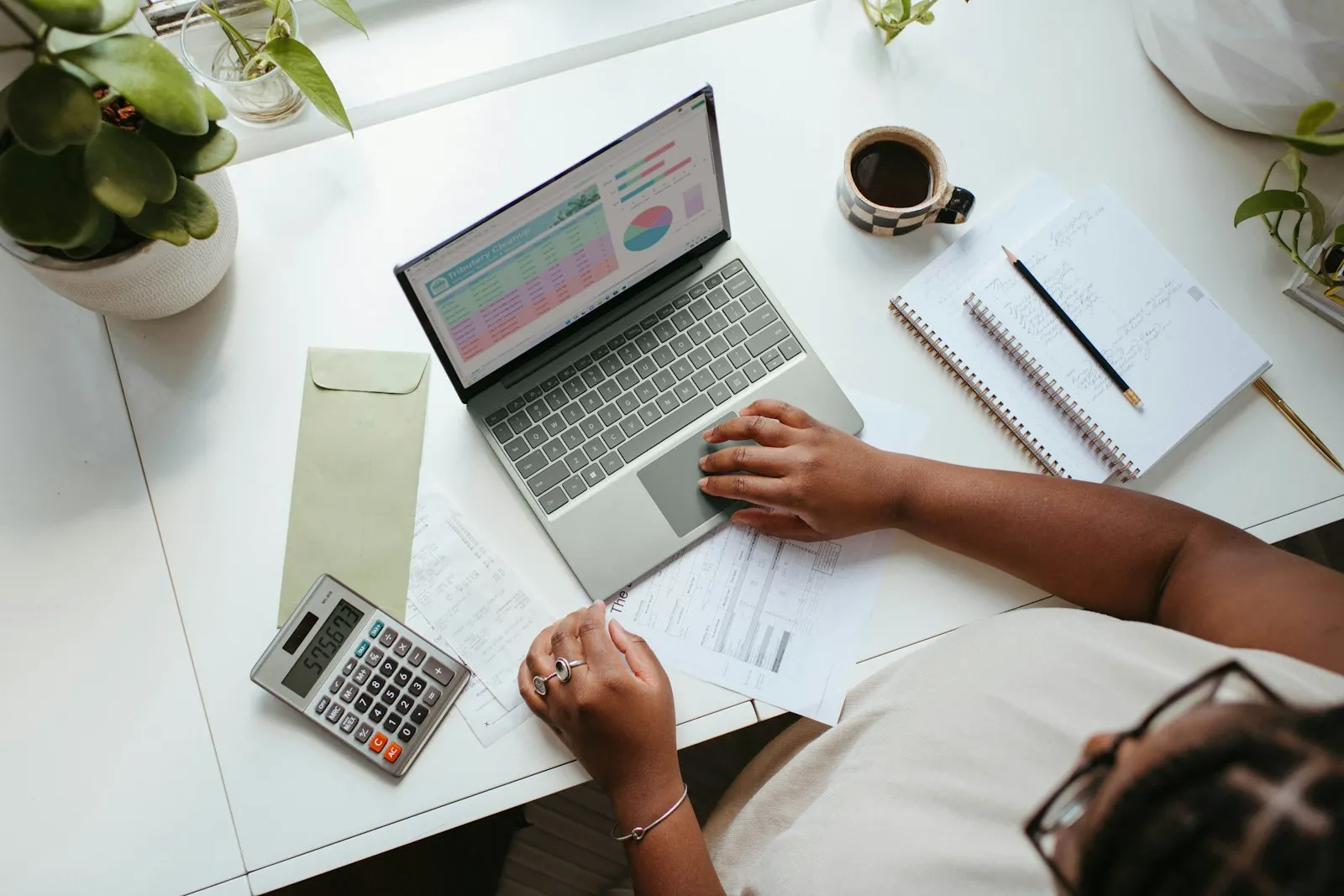 Bookkeeping at a desk with a laptop and calculator